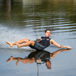 A barefoot waterskier wearing the Iron Sleeveless Wetsuit, leaning back on the water with a handle in hand.