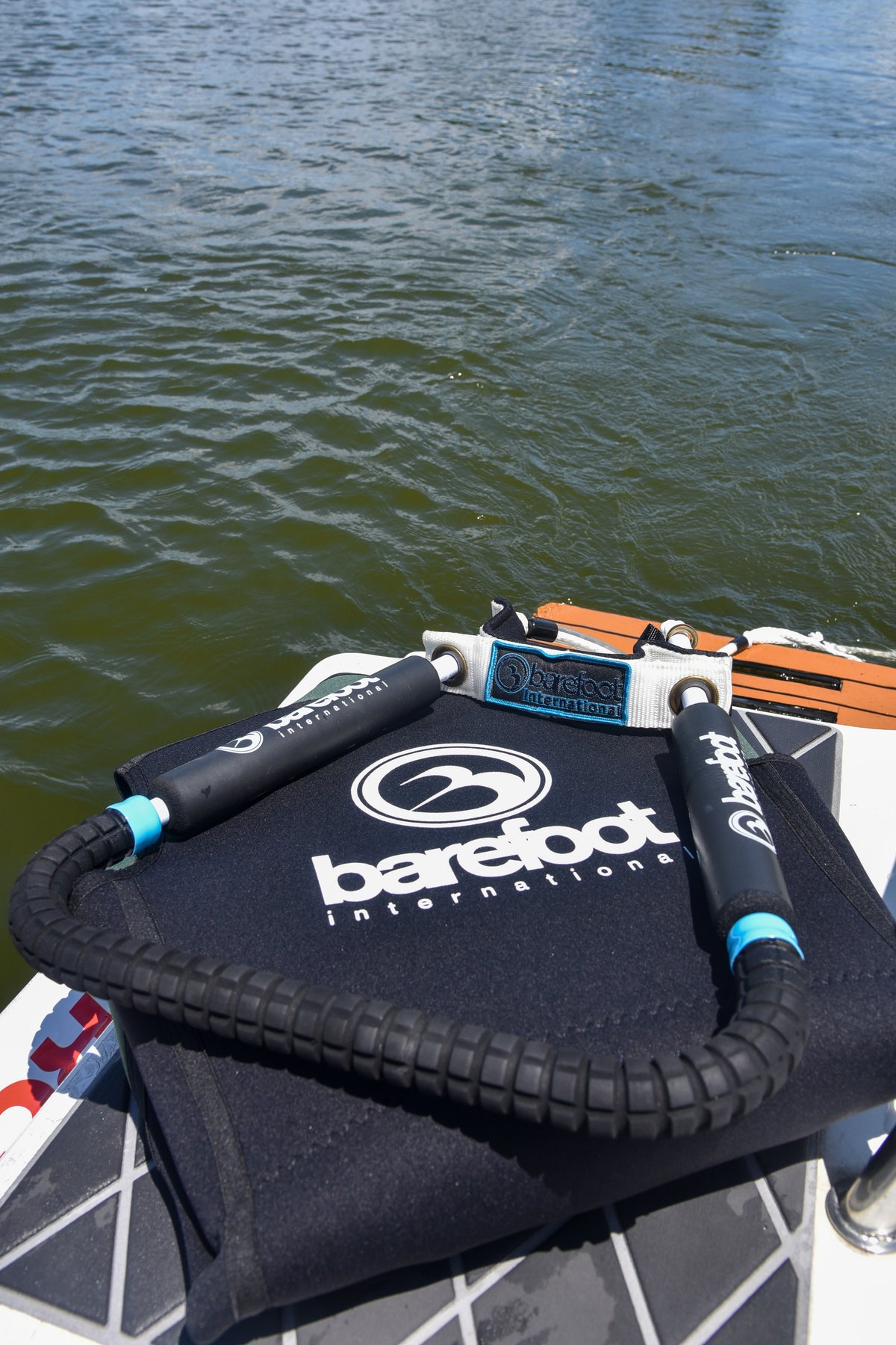 Front Toe Handle Full Wrap with black grips and toe strap, resting on a bag by the water.