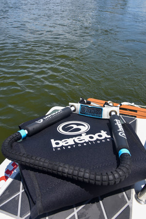 Front Toe Handle Full Wrap with black grips and toe strap, resting on a bag by the water.