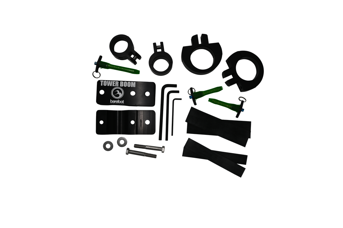 Top view of the Tower Boom Clamp Box hardware kit with black brackets, green pins, circular clamps, bolts, and rubber strips.