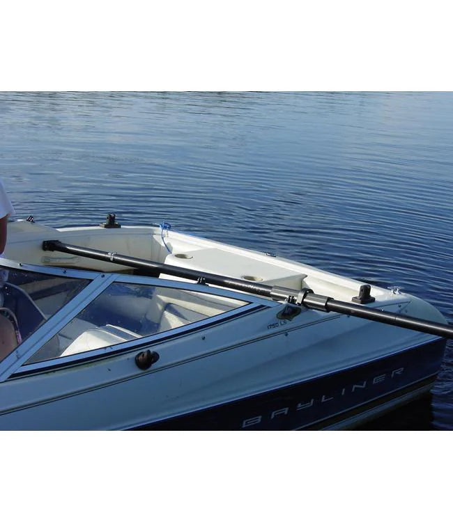 Deluxe Gunnel Mount Boom mounted across the front of a white and blue boat on a lake.