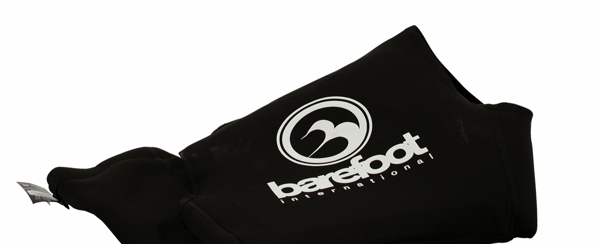 Close-up of the folded Iron Sleeveless wetsuit, highlighting the Barefoot International logo and stitching details.